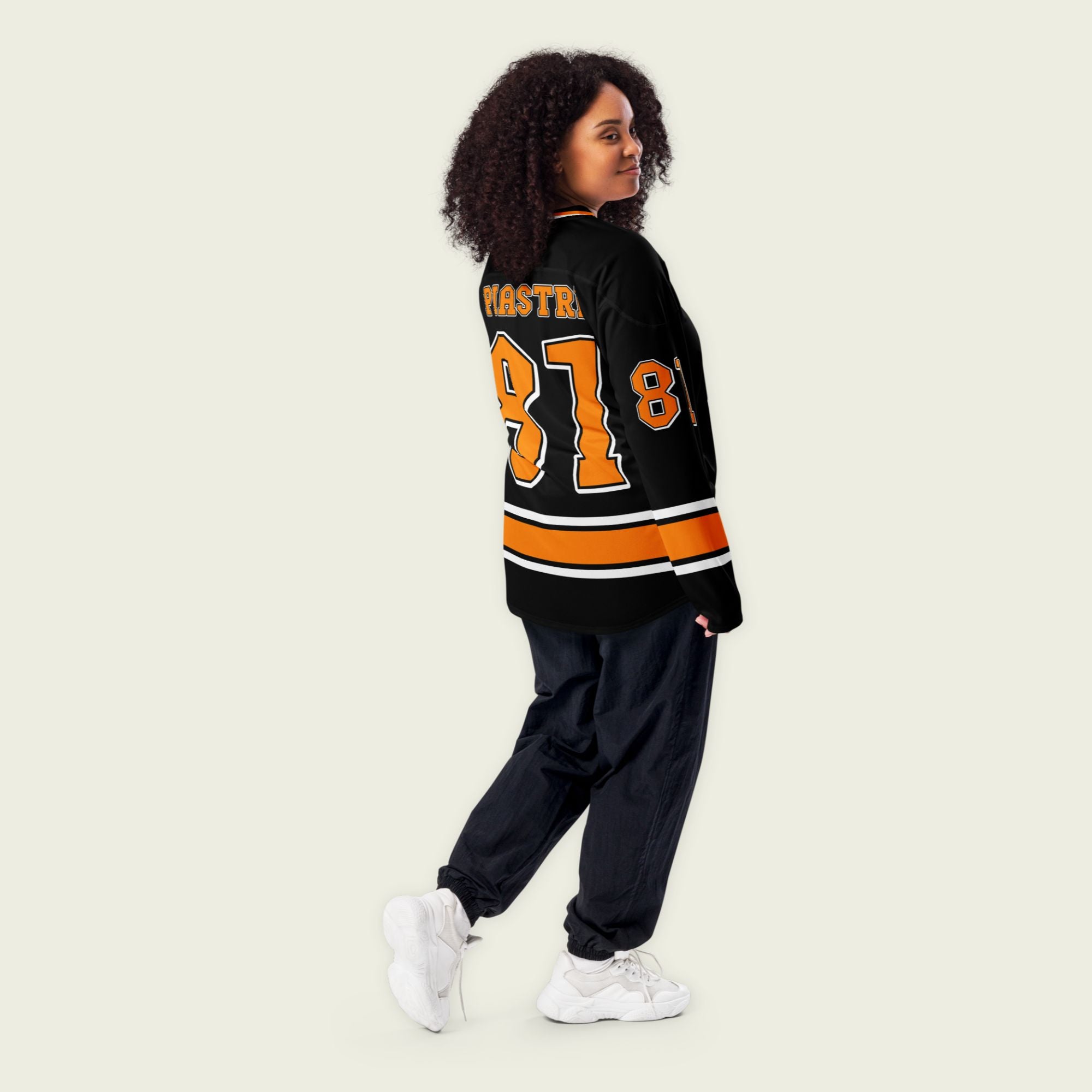 A black hockey jersey with Oscars piastri's McLaren F1 racing number 81 on the front and back in papaya orange, also the name Piastri is on the back in orange