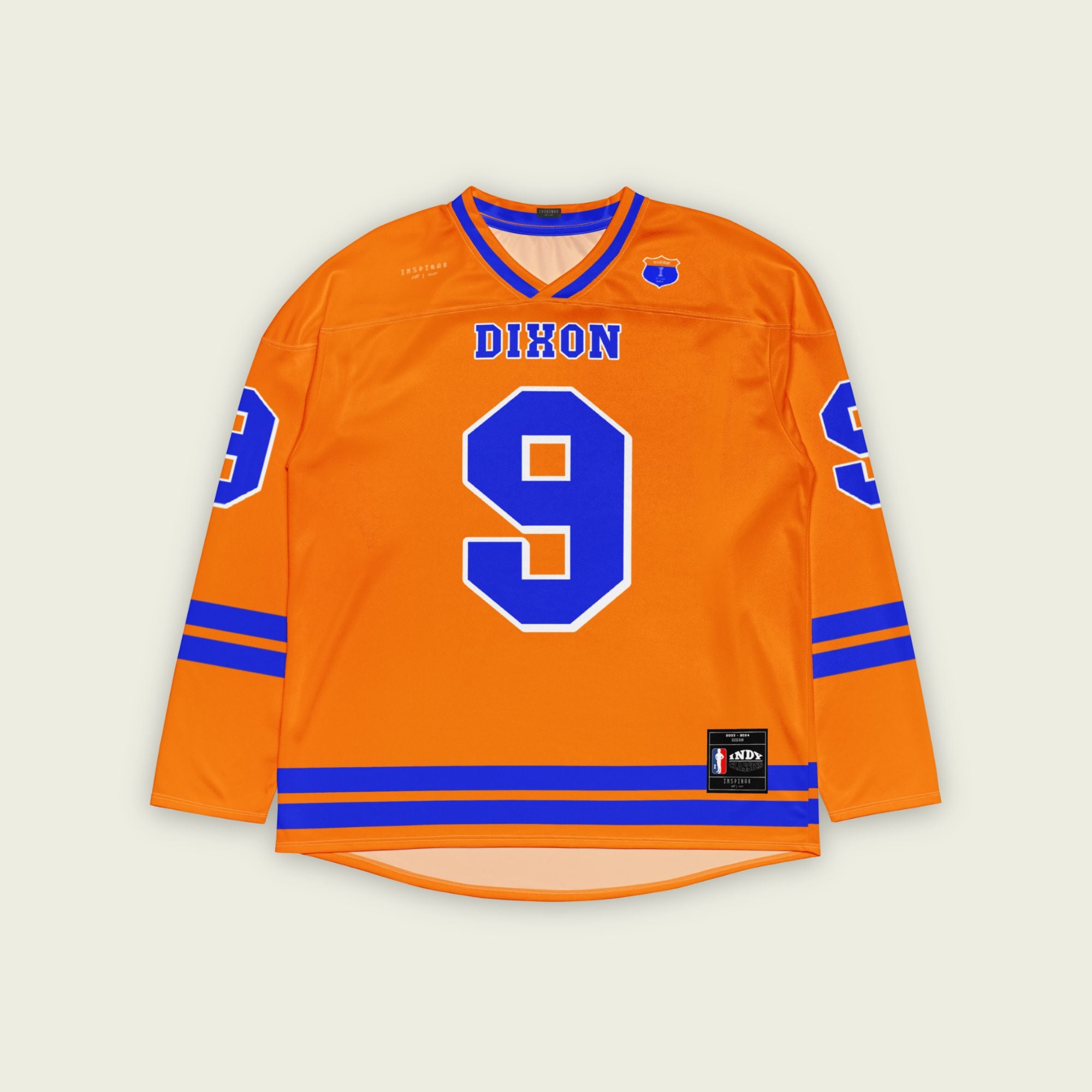 A orange hockey jersey with two blue lines at the bottom and on the arms. It has the number 9 for Scott dixon's race number in blue with a white outline. It also has the name Dixon on the front and back