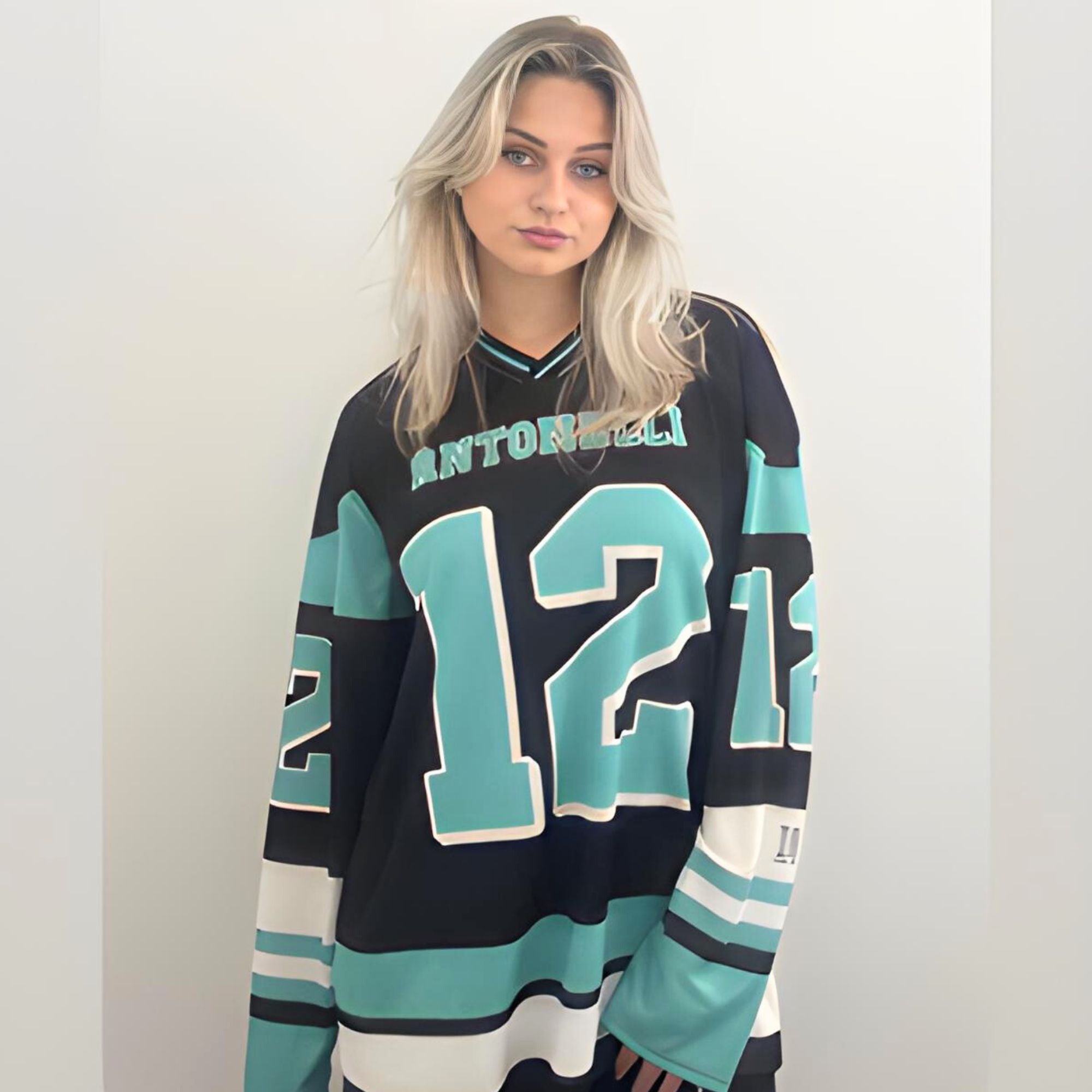 A black and turquoise hockey jersey with Andrea Kimi Antonelli's Mercedes F1 racing number 12 in turquoise on the front and back. It has the name Antonelli on the back and front in turquoise as well.